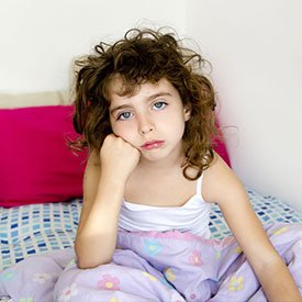 Young girl in bed because she has lice
